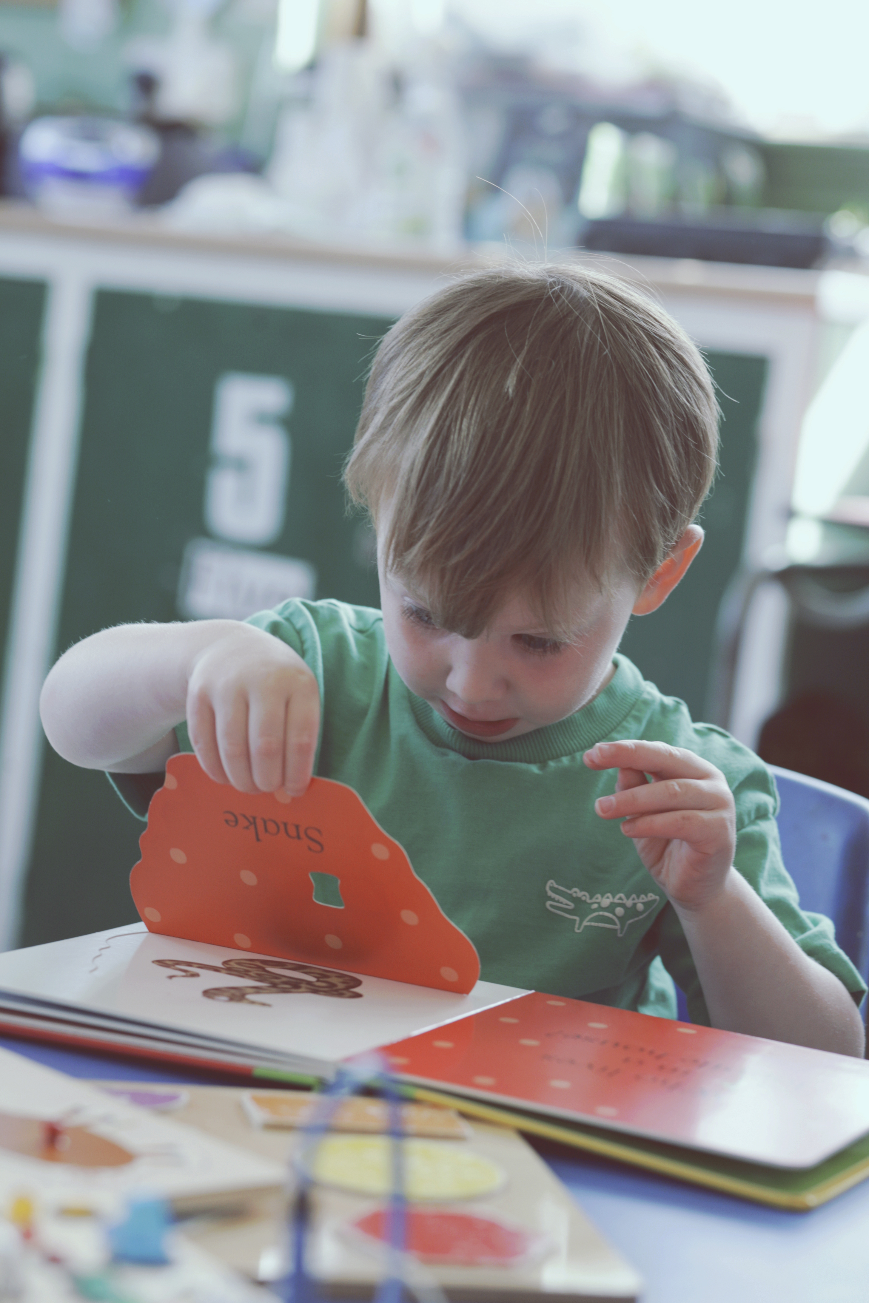 Child reading a book during nursery photography session in Cullercoats